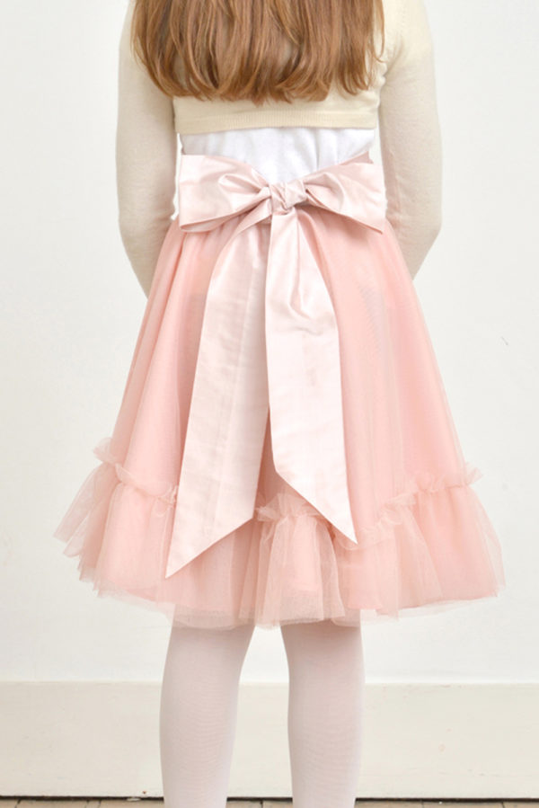 A flowergirl wearing a pink tulle skirt with a pink bow sash - The Little Wedding Company