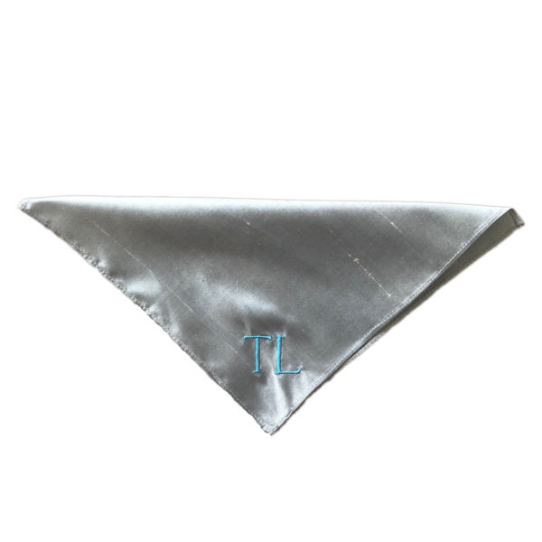 A folded blue silk pocket square with embroidered initials - The Little Wedding Company