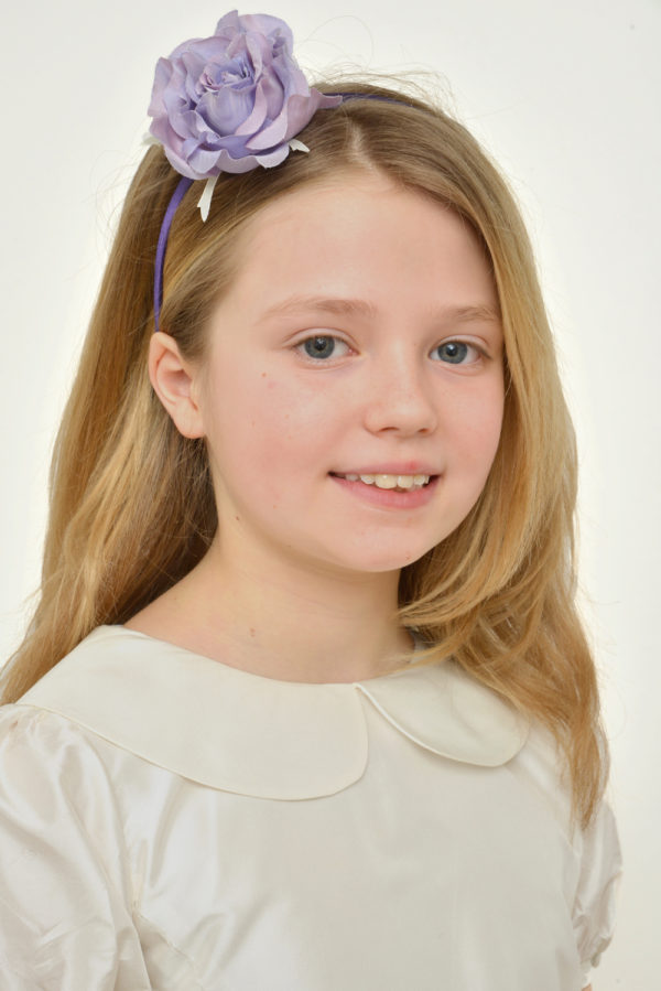 A girl wearing a lavender hairband with a silk rose - The Little Wedding Company