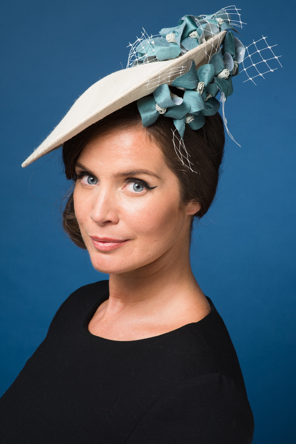 A lady wearing a cream hat with blue flowers - TLWC