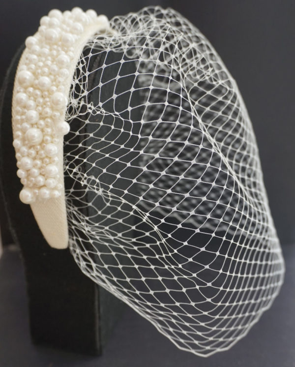 A picture of an ivory pearl hairband with a net over the face