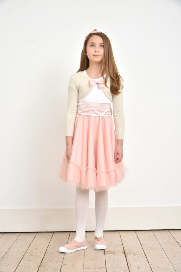 A girl wearing a pale pink tulle skirt with sash - The Little Wedding Company