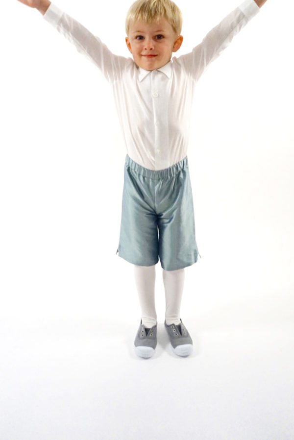 A boy wearing pale blue silk shorts and a cotton shirt - The Little Wedding Company